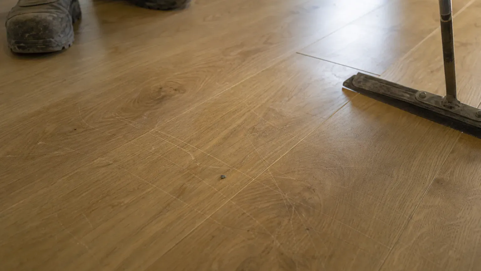Rayures sur un parquet neuf causées par une mauvaise méthode lors du nettoyage de fin de chantier