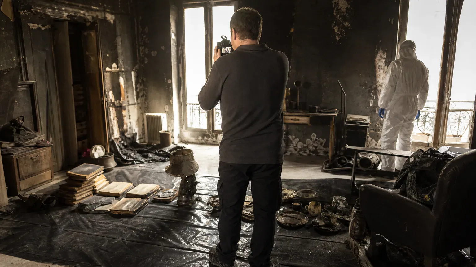 Objets abîmés alignés sur une bâche et photographiés pour l'inventaire des biens après incendie