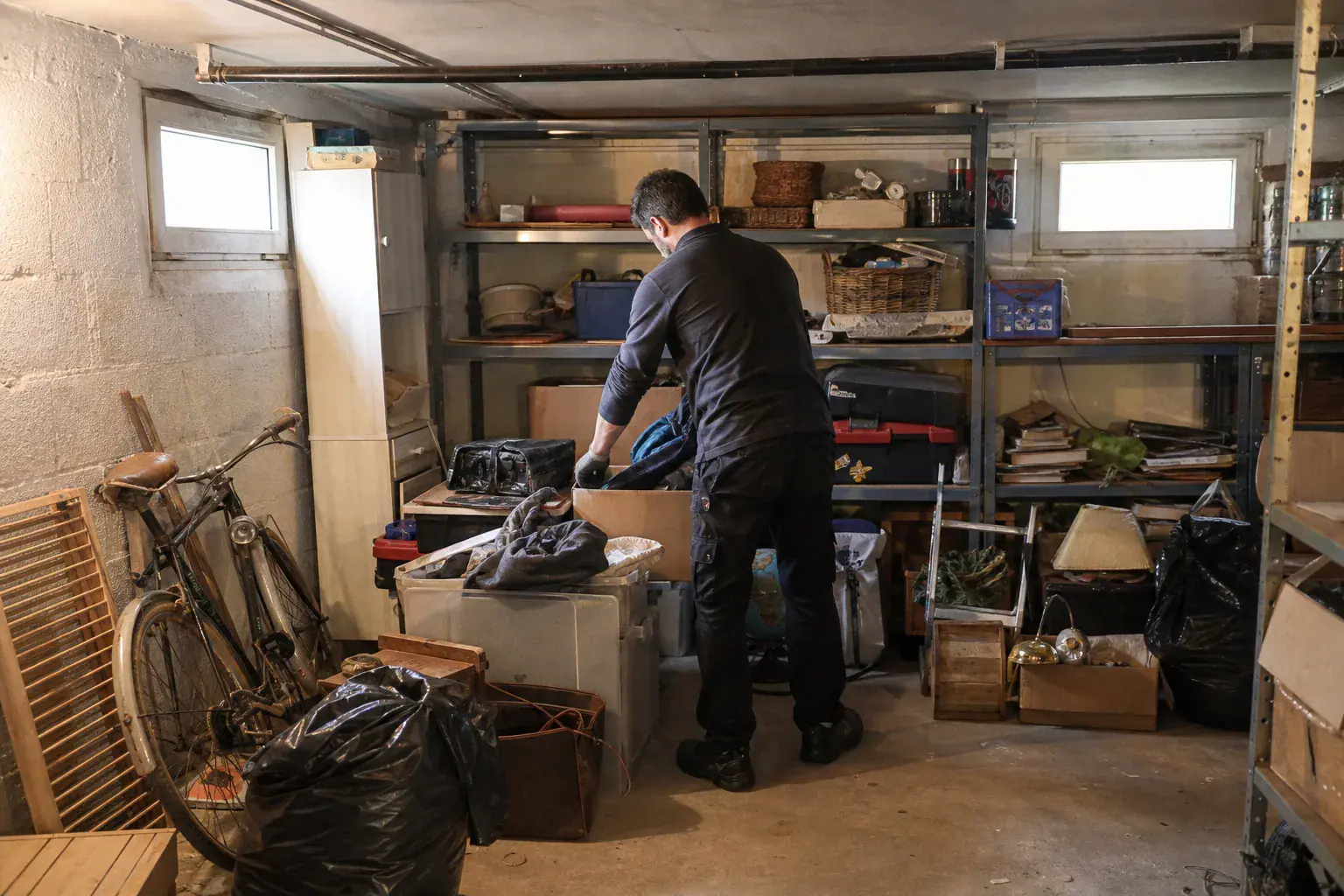Tri d'objets en piles à donner, recycler et jeter dans le sous-sol d'un pavillon en Essonne