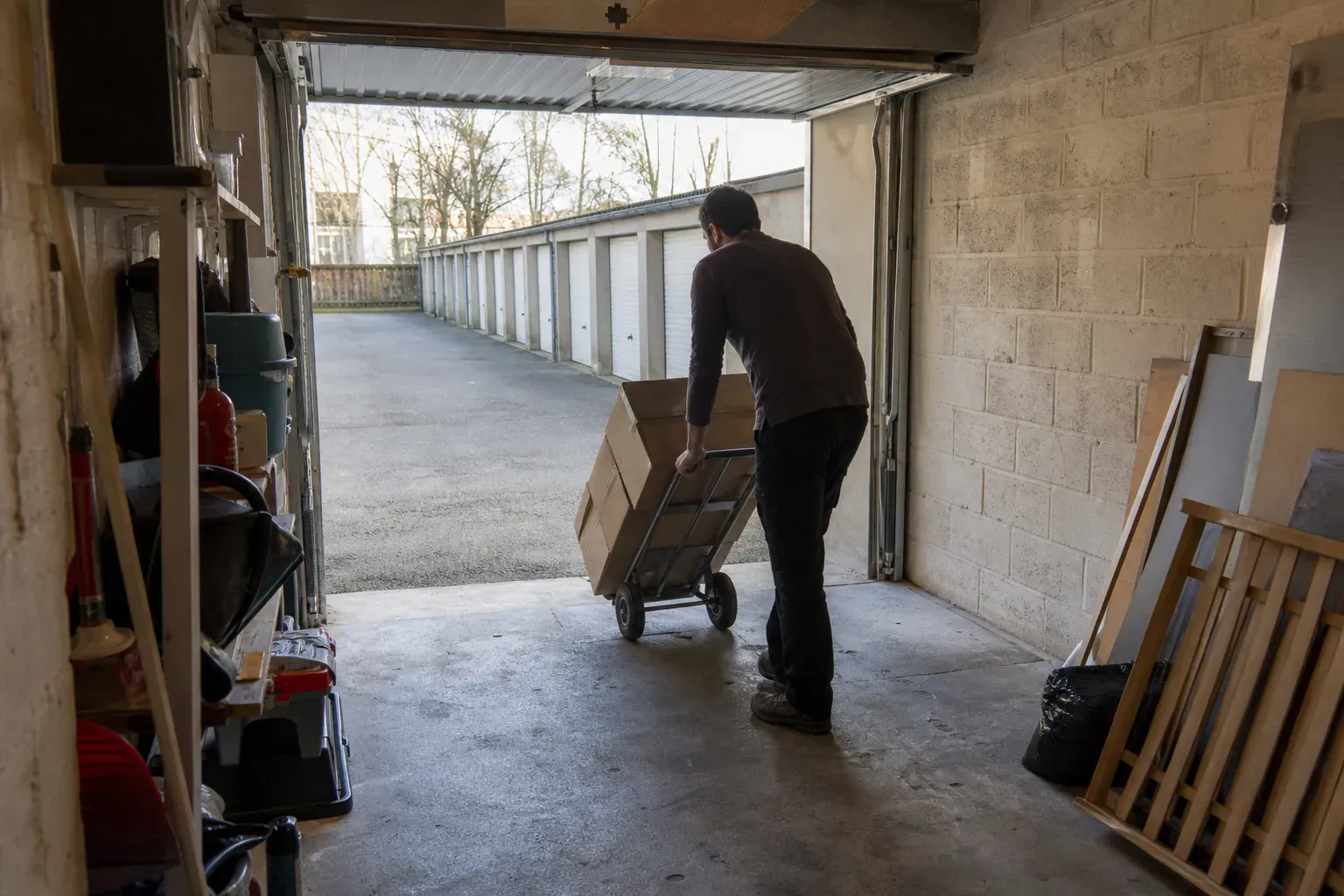 Chargement de cartons sur un diable dans un box de garage du Val-d'Oise lors d'un débarras
