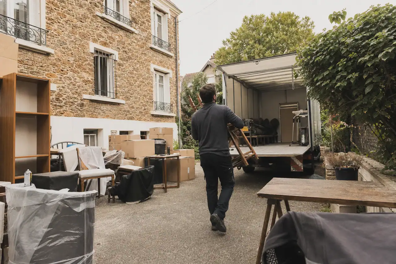 Meubles et cartons sortis dans le jardin d'un pavillon du Val-de-Marne pendant un débarras