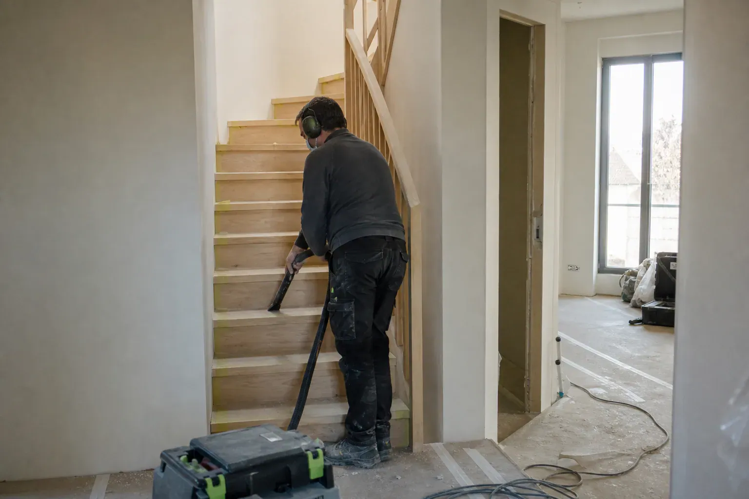 Aspiration de la poussière de plâtre dans l'escalier d'une maison neuve de Seine-et-Marne après travaux