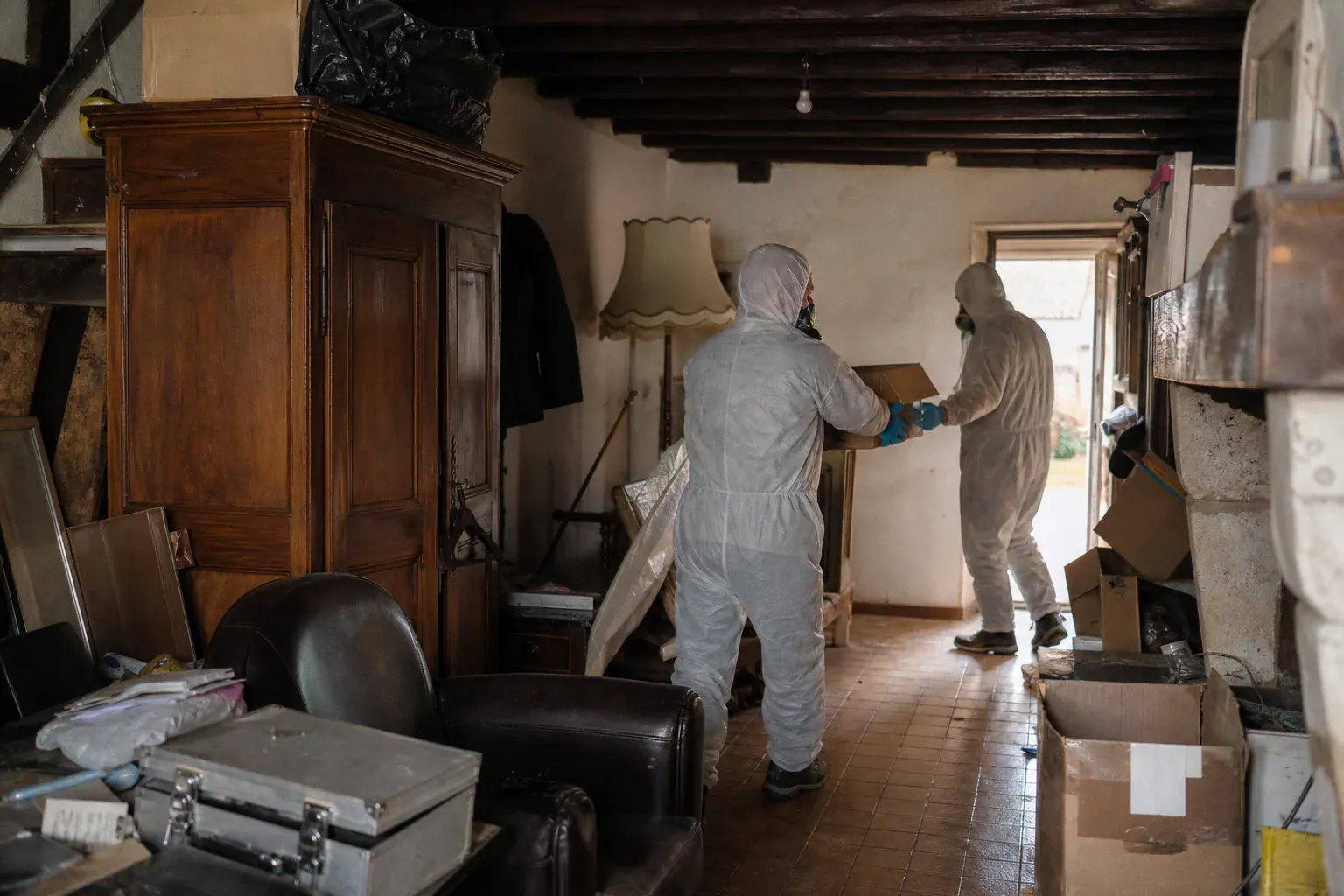 Deux techniciens évacuant des cartons accumulés d'une maison de Seine-et-Marne, syndrome de Diogène