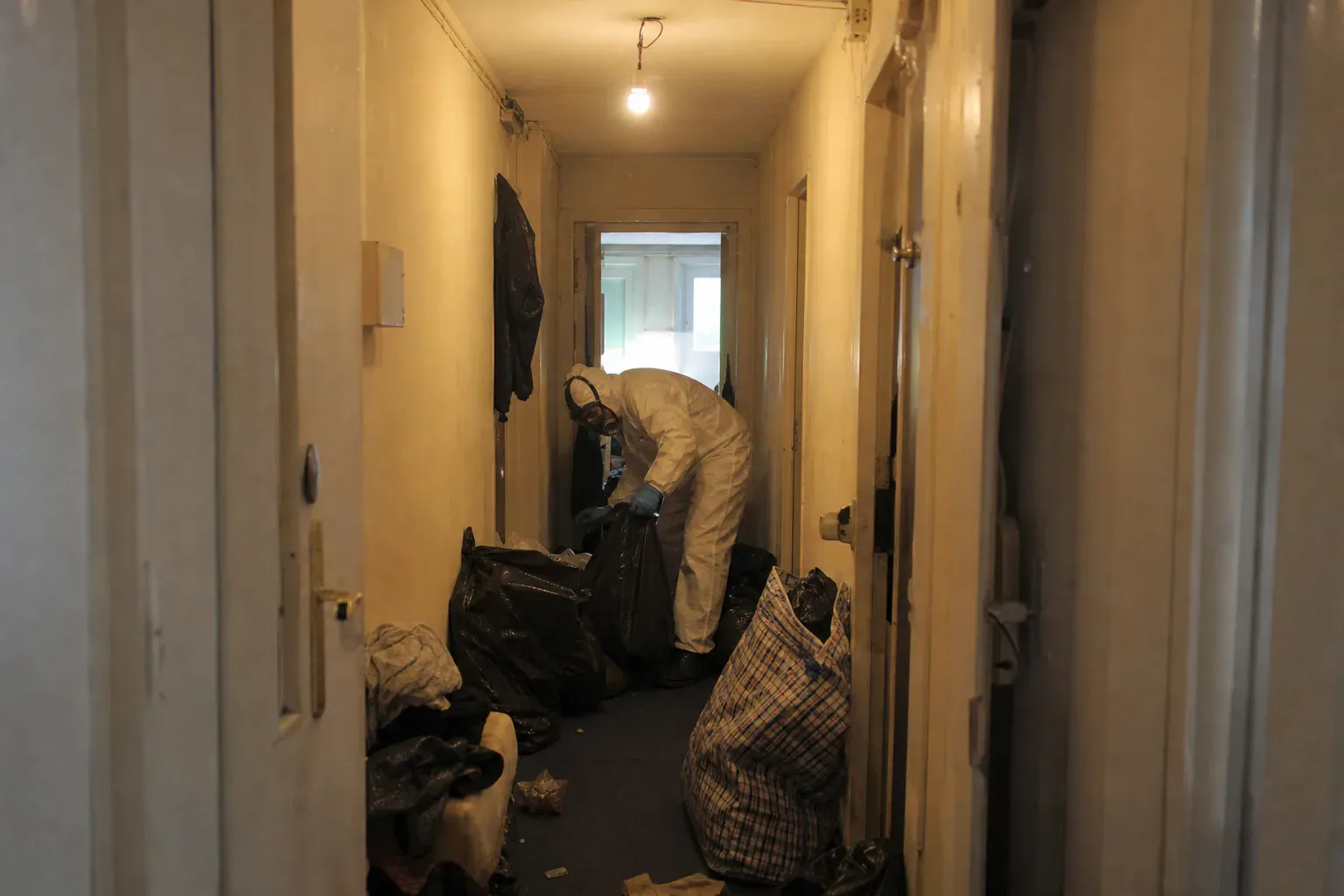 Dégagement d'un couloir encombré de sacs dans un appartement de Seine-Saint-Denis, syndrome de Diogène